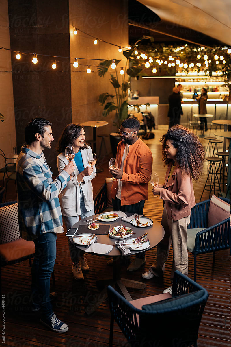 Happy diverse friends with drinks in restaurant