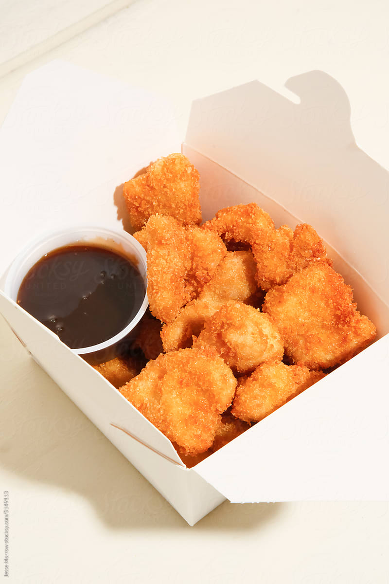 Container of chicken nuggets and sauce.
