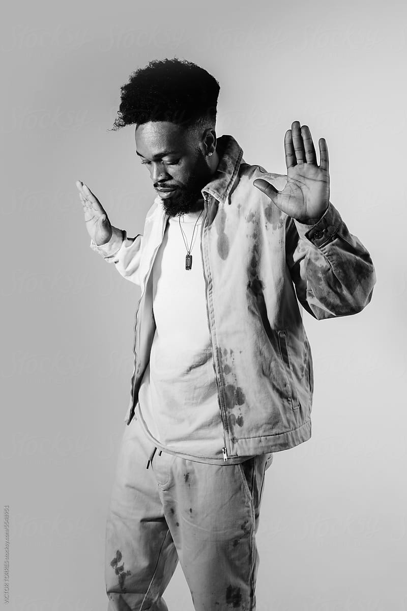 Serious black man showing stop gesture on gray background
