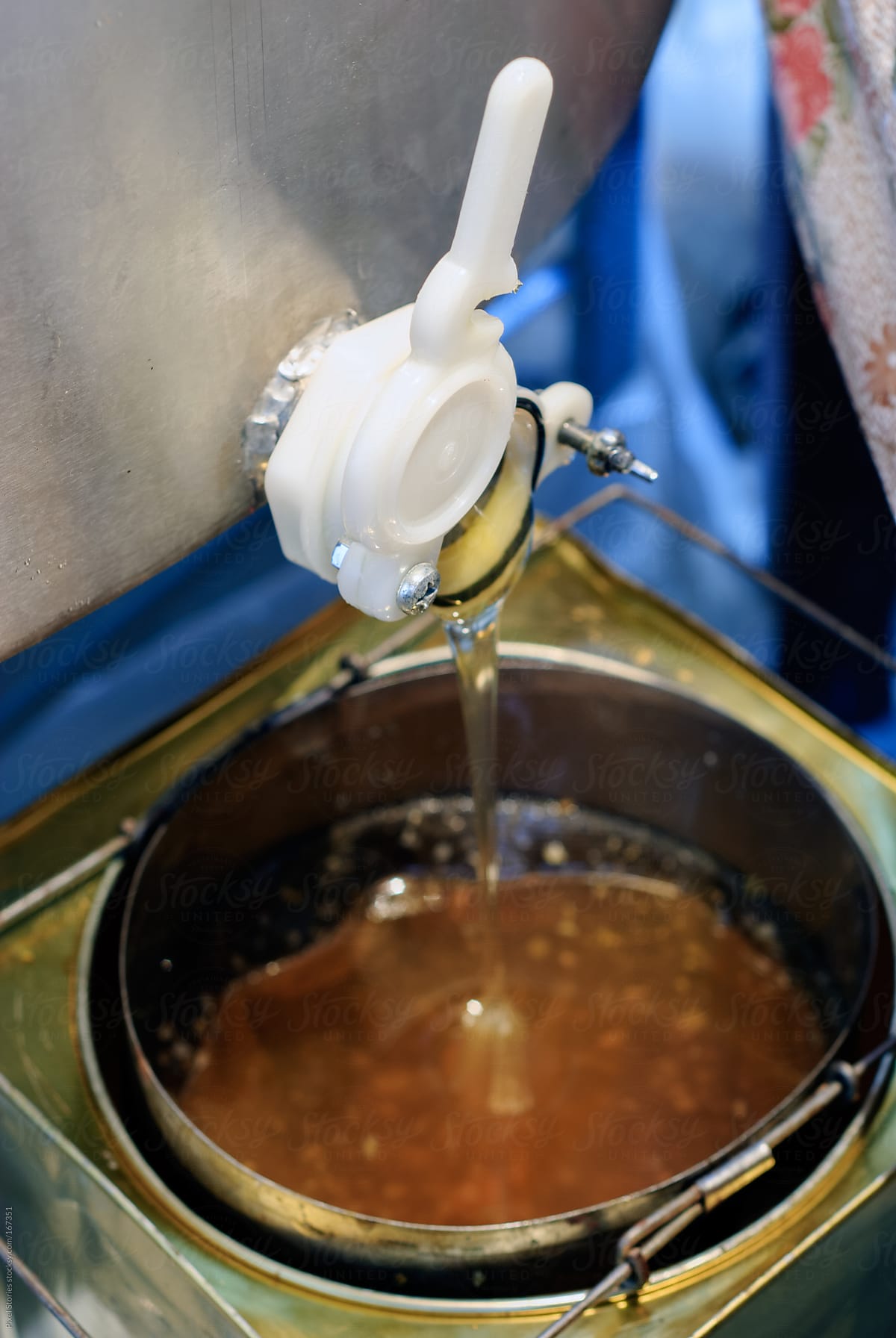 Honey extractor with honey flowing out of it