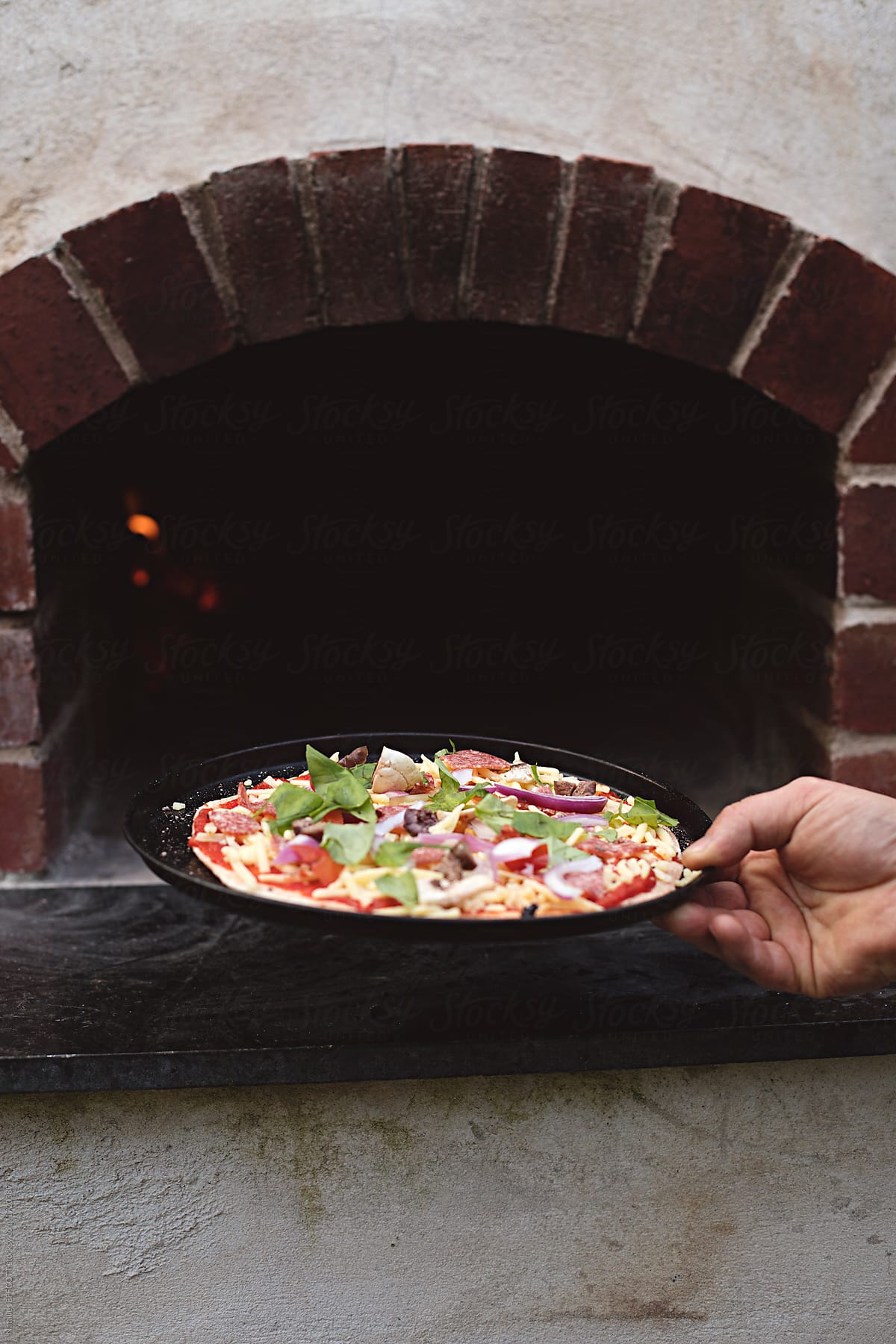 outdoors cooking pizza in wood fire oven