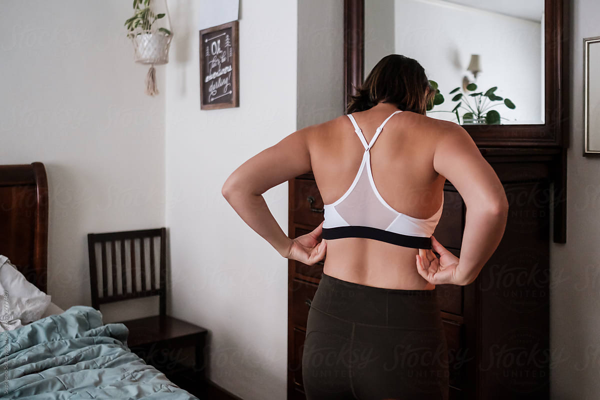 Woman Putting On Her Sport Bra Before Exercise by Stocksy Contributor  Take A Pix Media - Stocksy