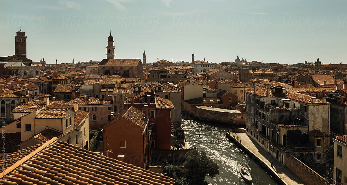 Aerial View Of Venice With Old Rustic Houses,Boat Canals And Church Towers Across City.