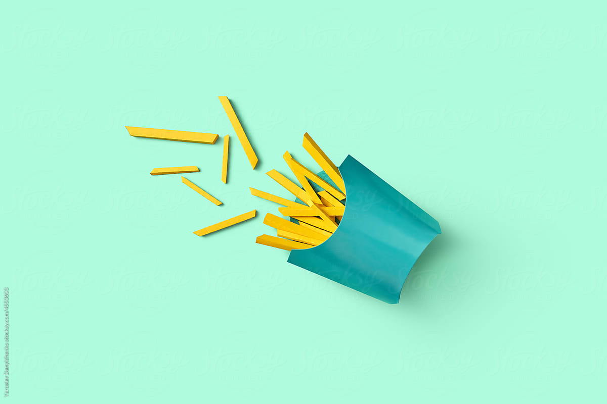 Papercraft french fries inside box on light blue background