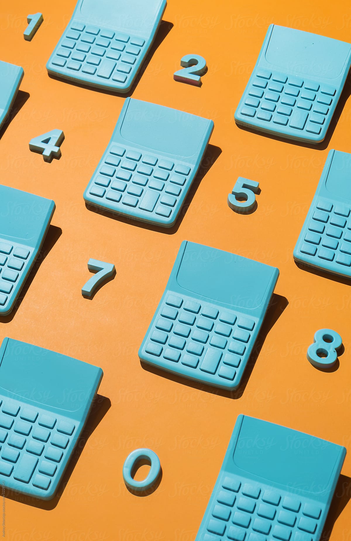 Blue pocket calculators with numbers on orange background.