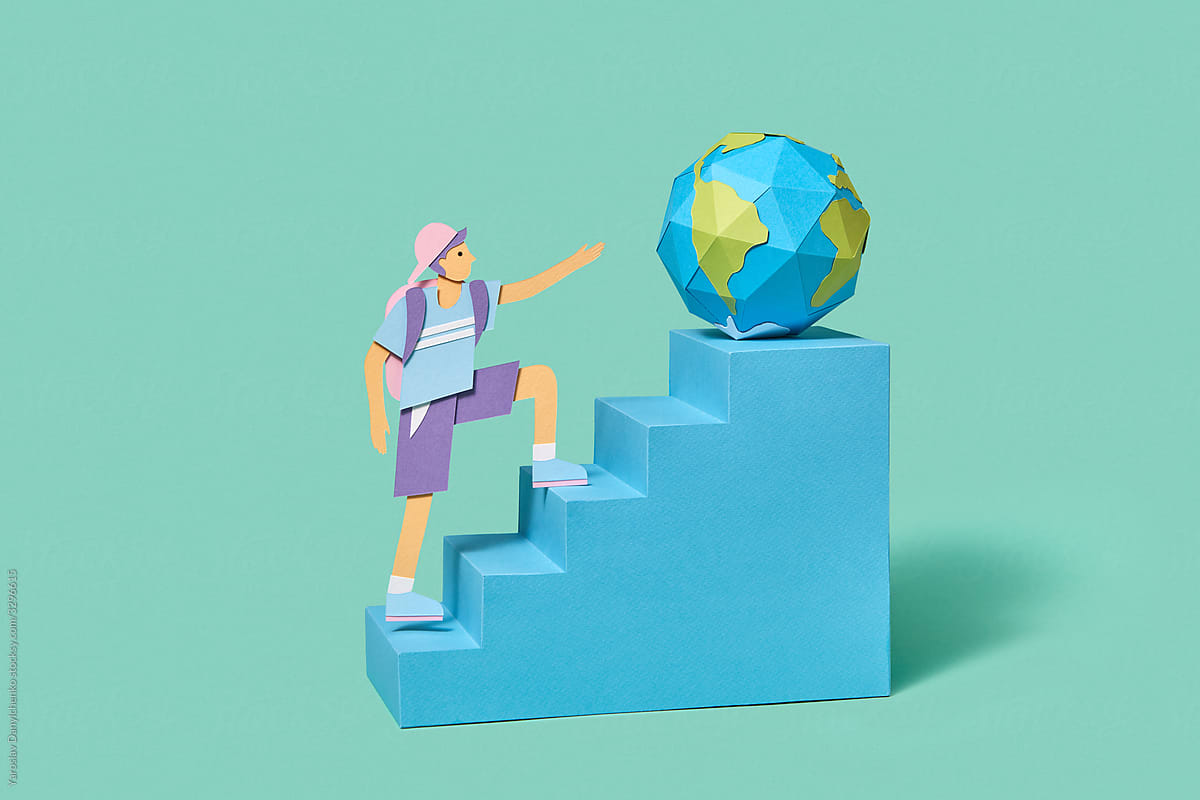 Papercraft school boy on a staircase with globe.