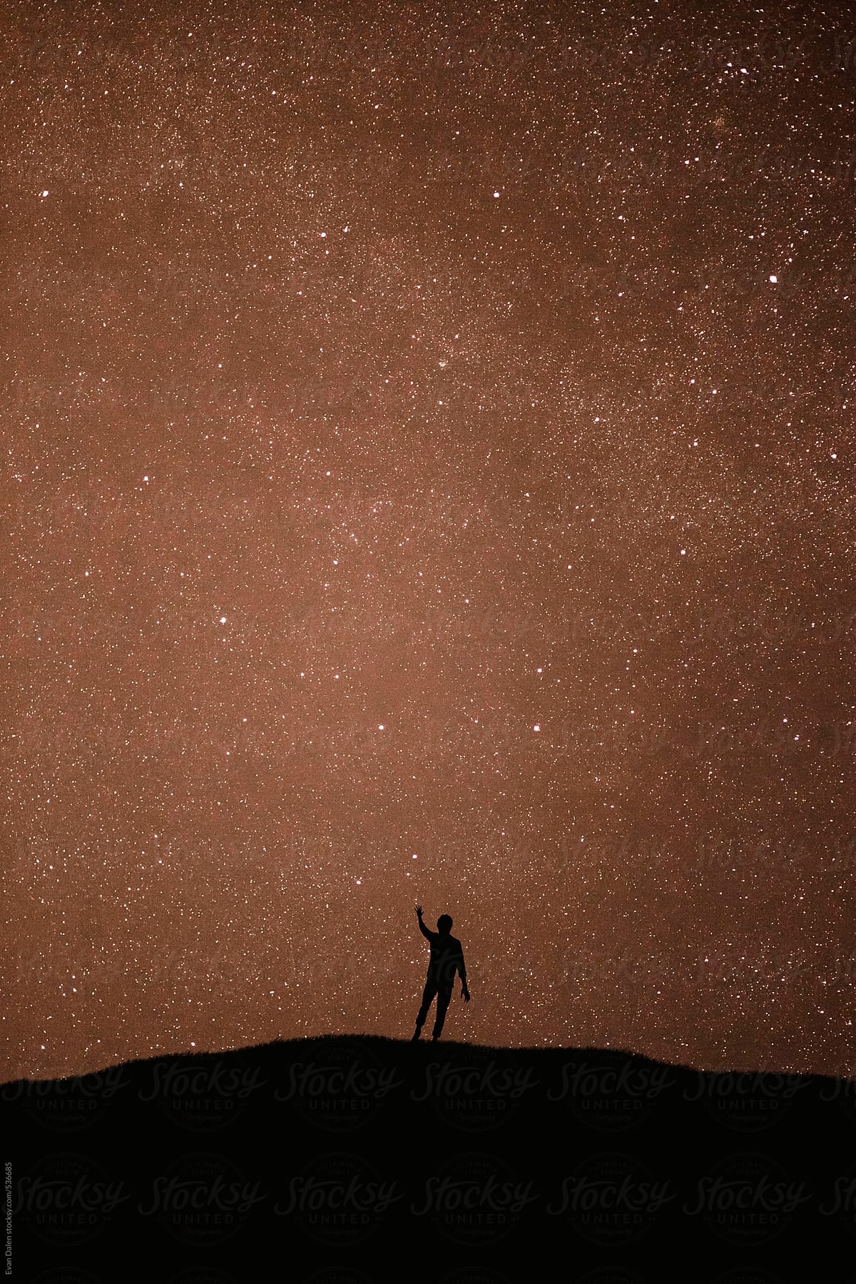 Silhouette of man reaching for the stars