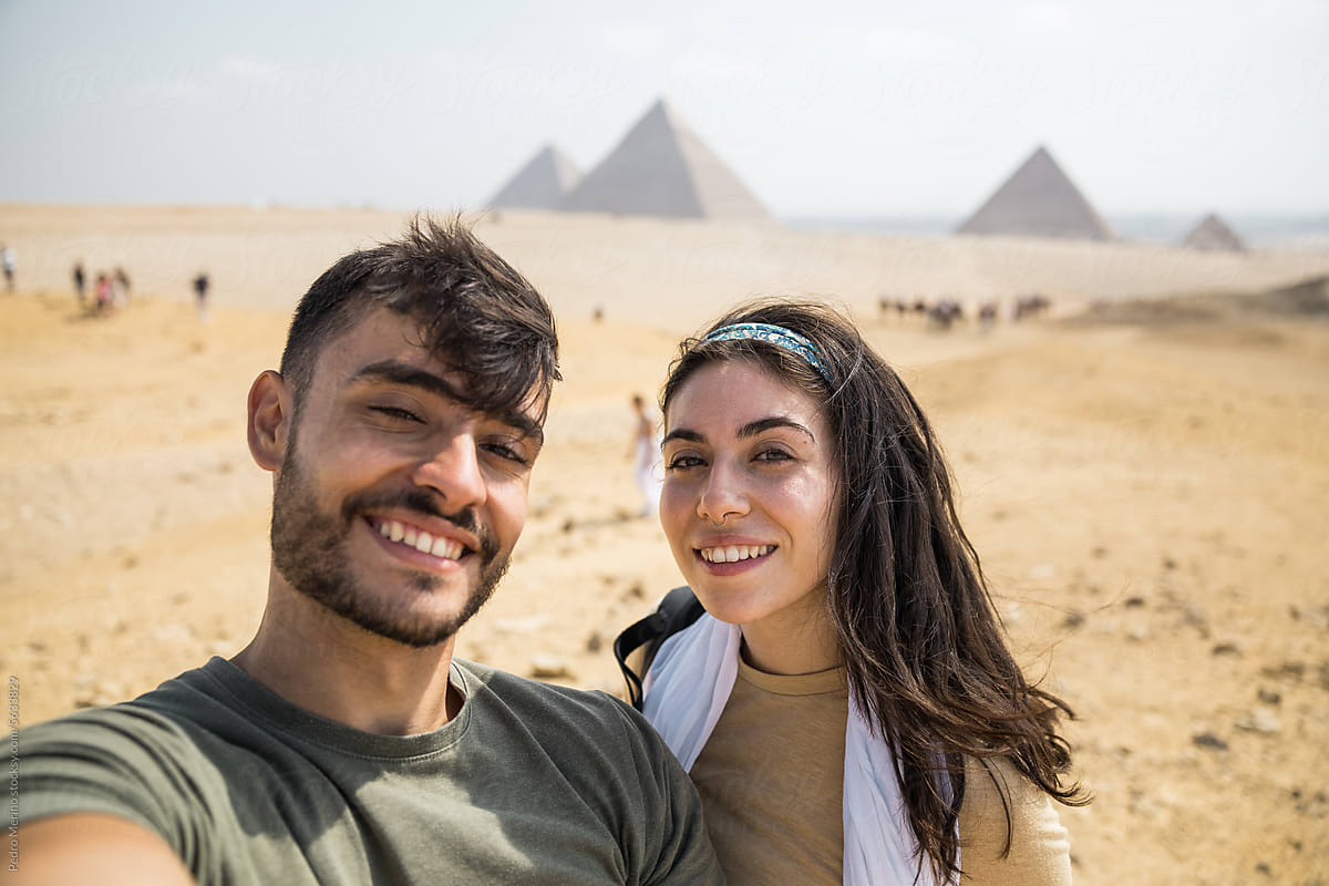 Selfie of a smiling couple visiting the pyramids of Egypt.
