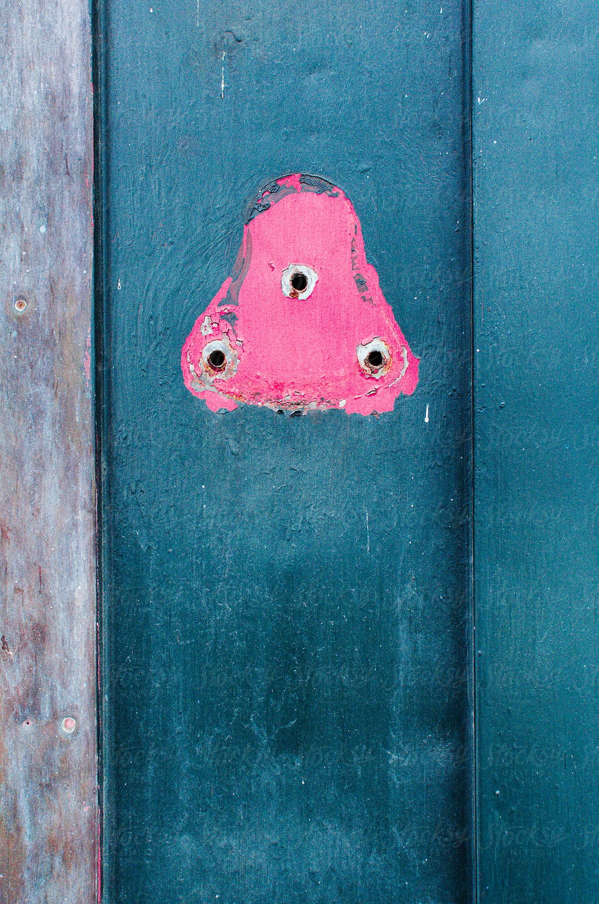 pink triangle in peeling paint on metal