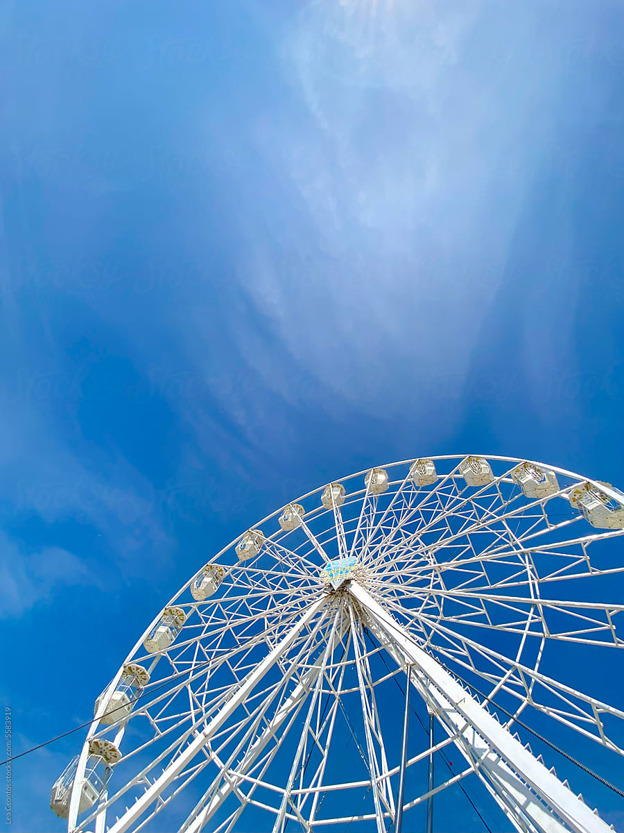 Giant ferris wheel against the bright blue summer sky.