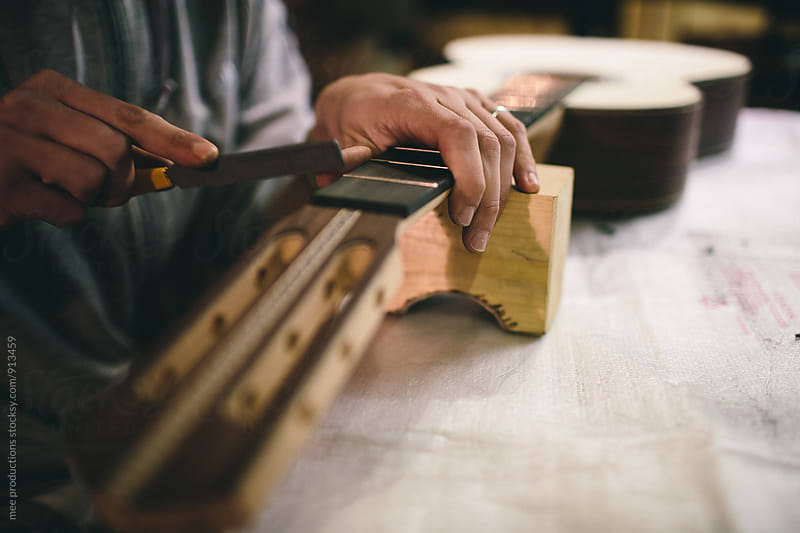 Young luthier building spanish guitars in his workshop
