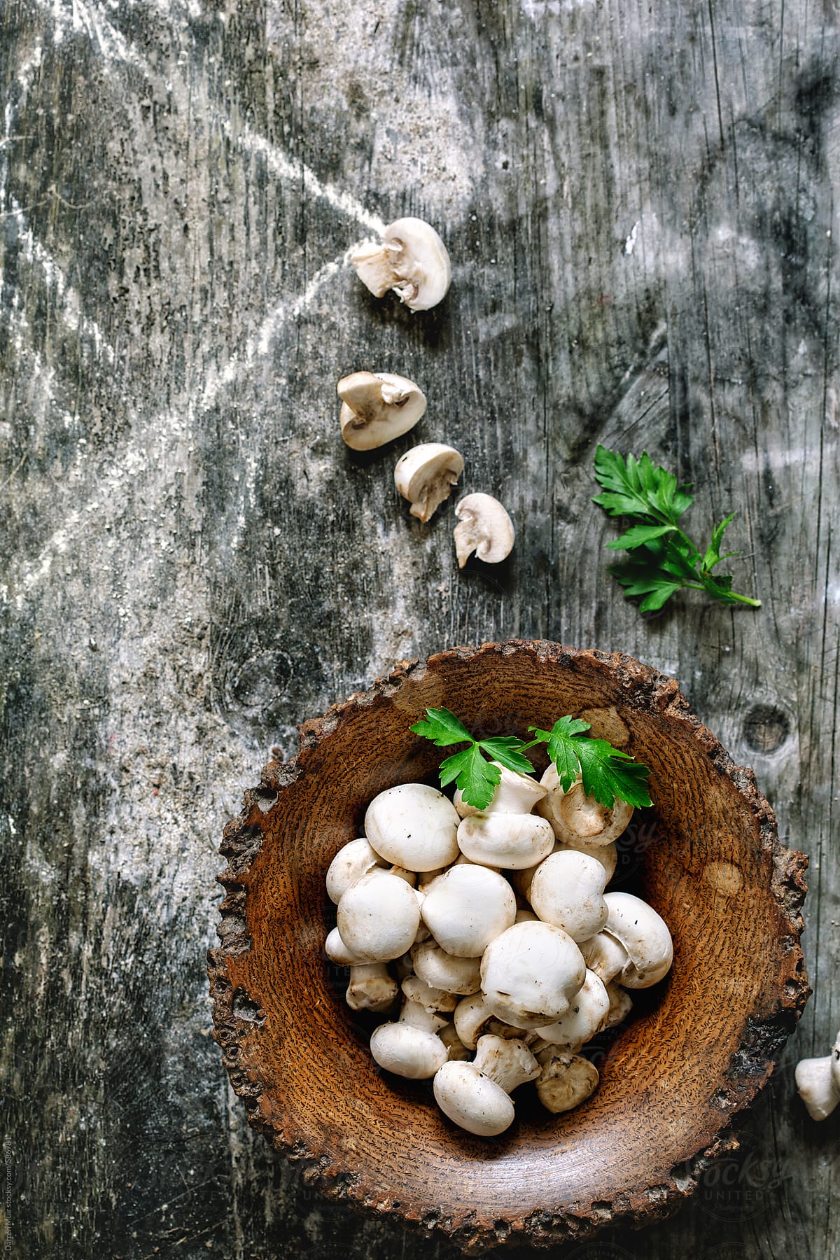 Baby button mushrooms in wooden bowl.