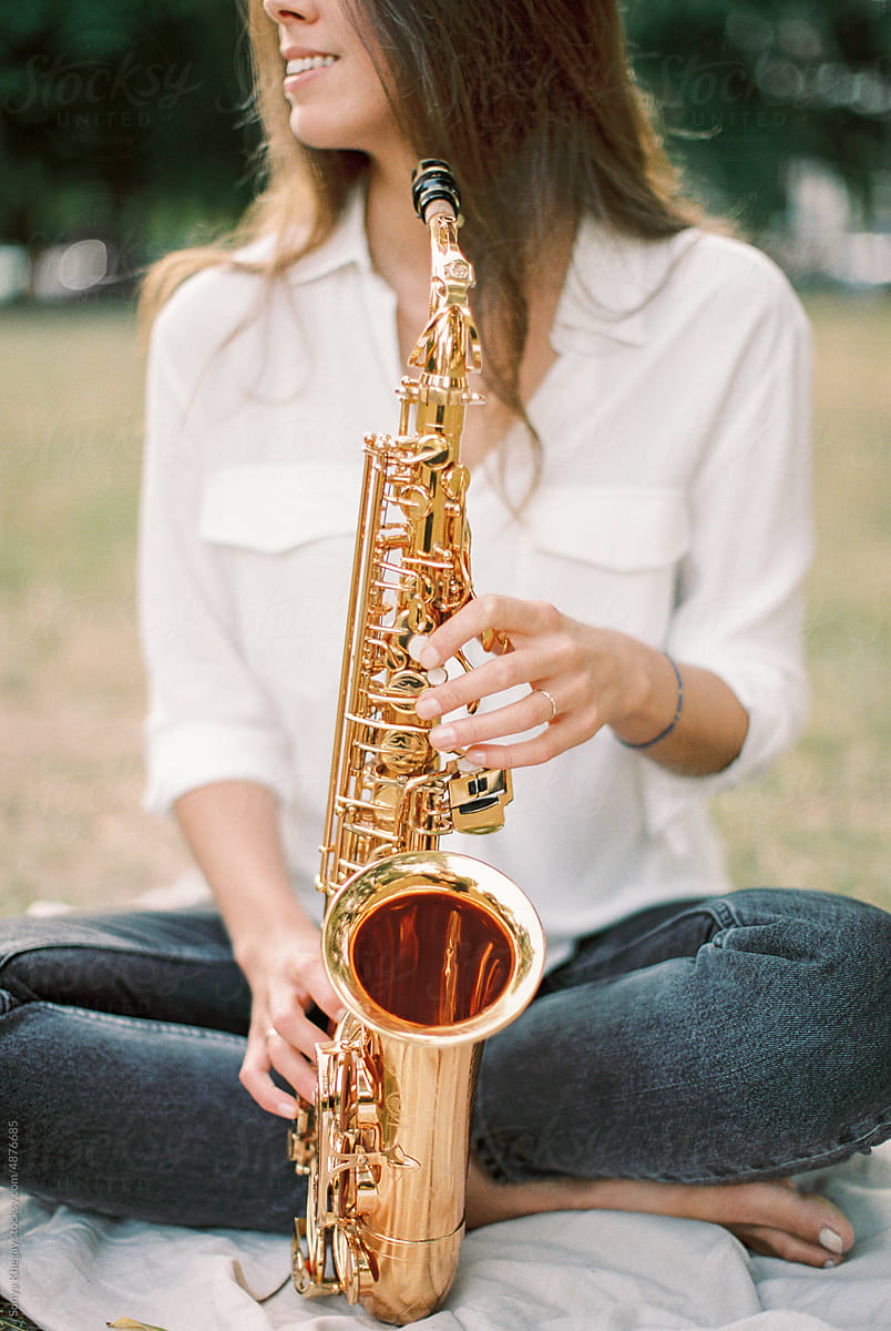 woman in a park with a saxophone