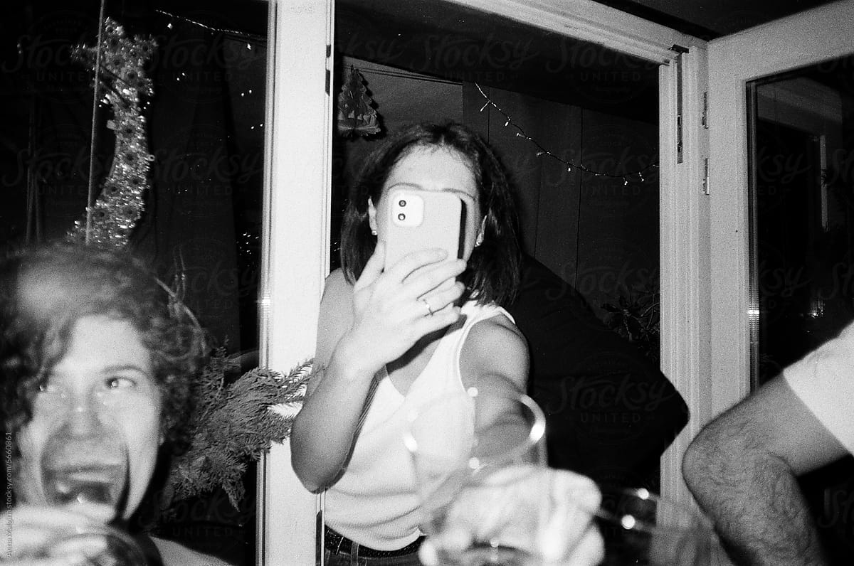 A woman taking photo with cell phone of a cheers at the party