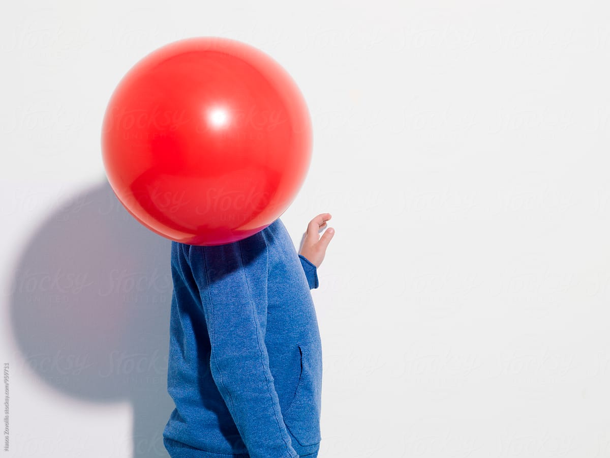 A balloon in front of a kid\'s face