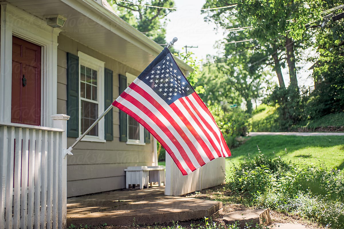 American flag displayed on the porch of a residential home.