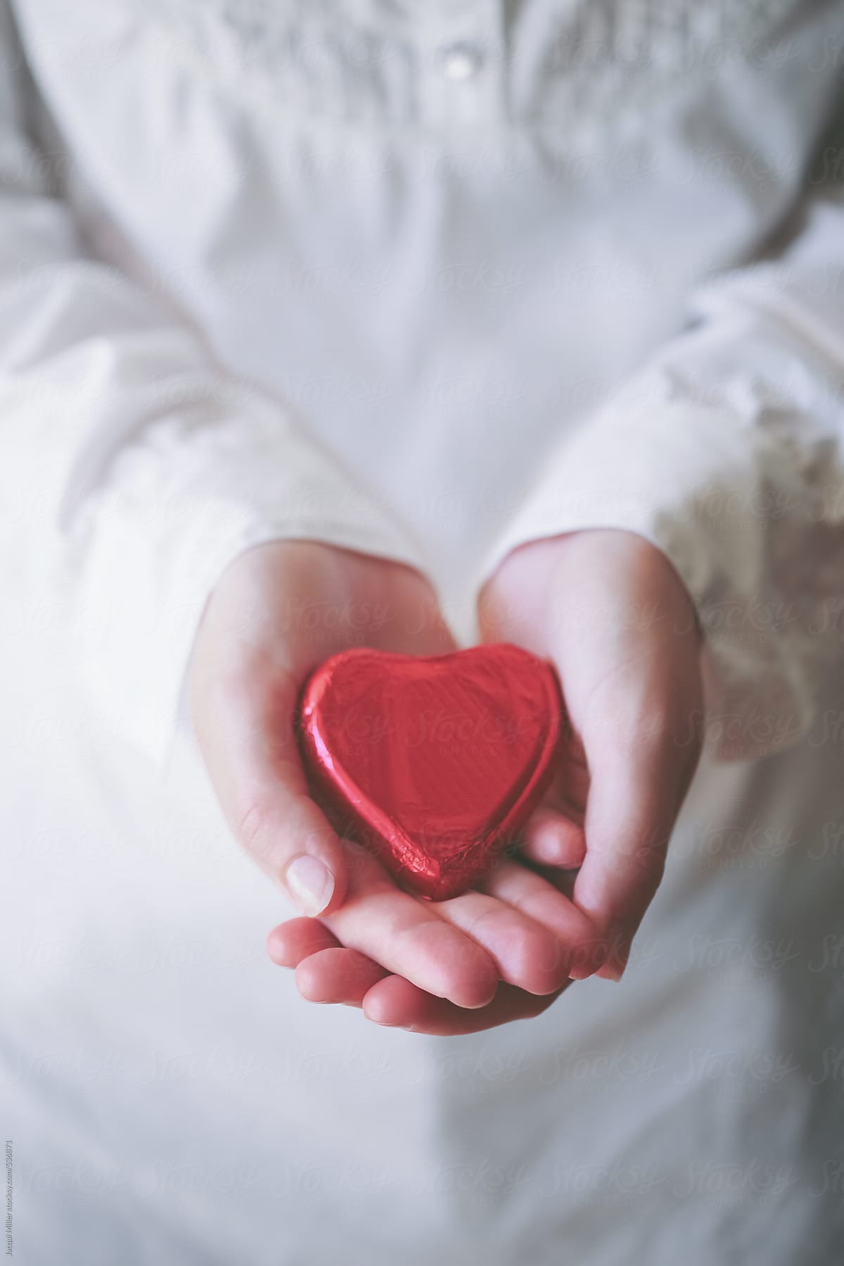 Young woman\'s hands holding a red heart for valentines day