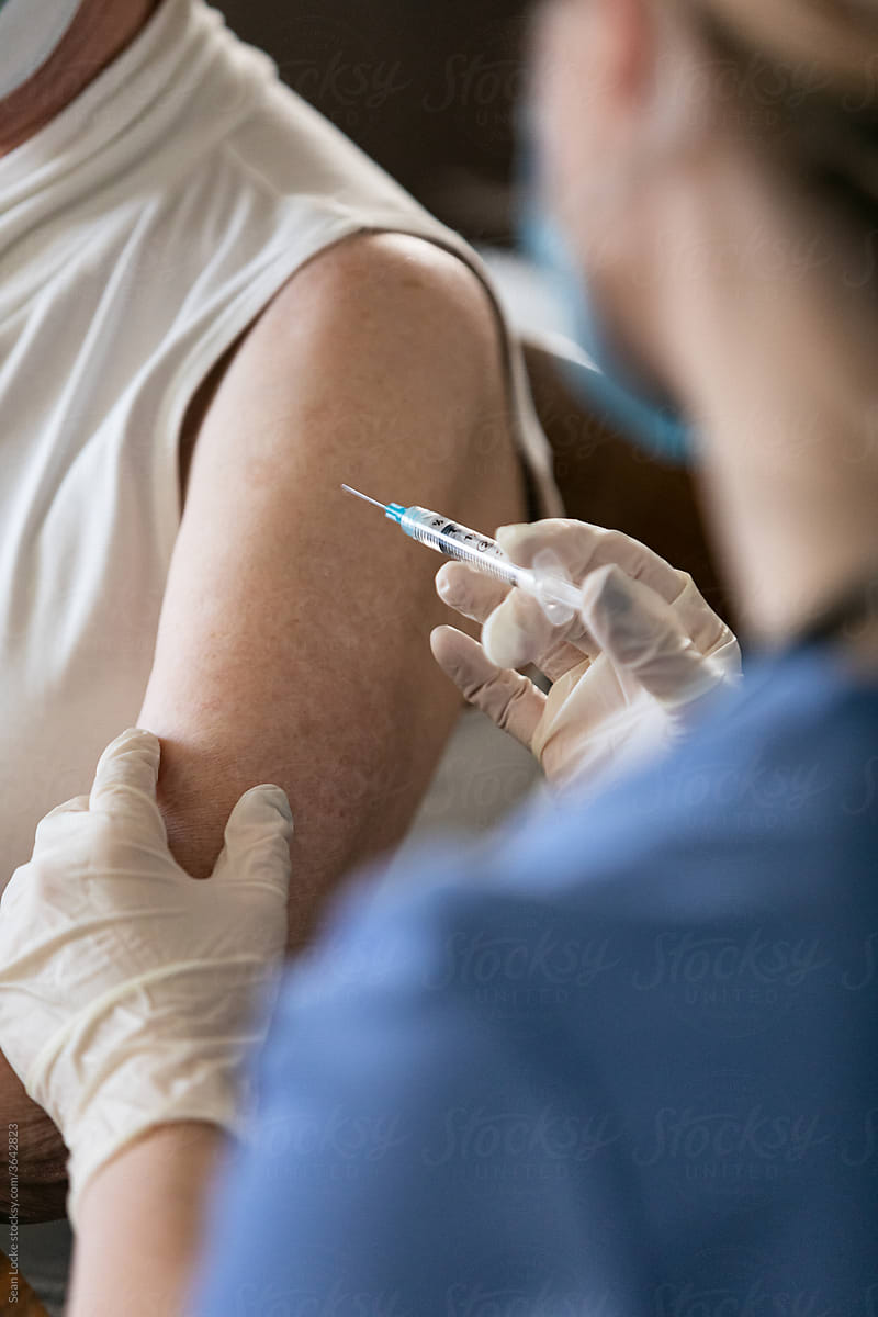 Health: Nurse Holds Syringe To Vaccinate Senior At Home