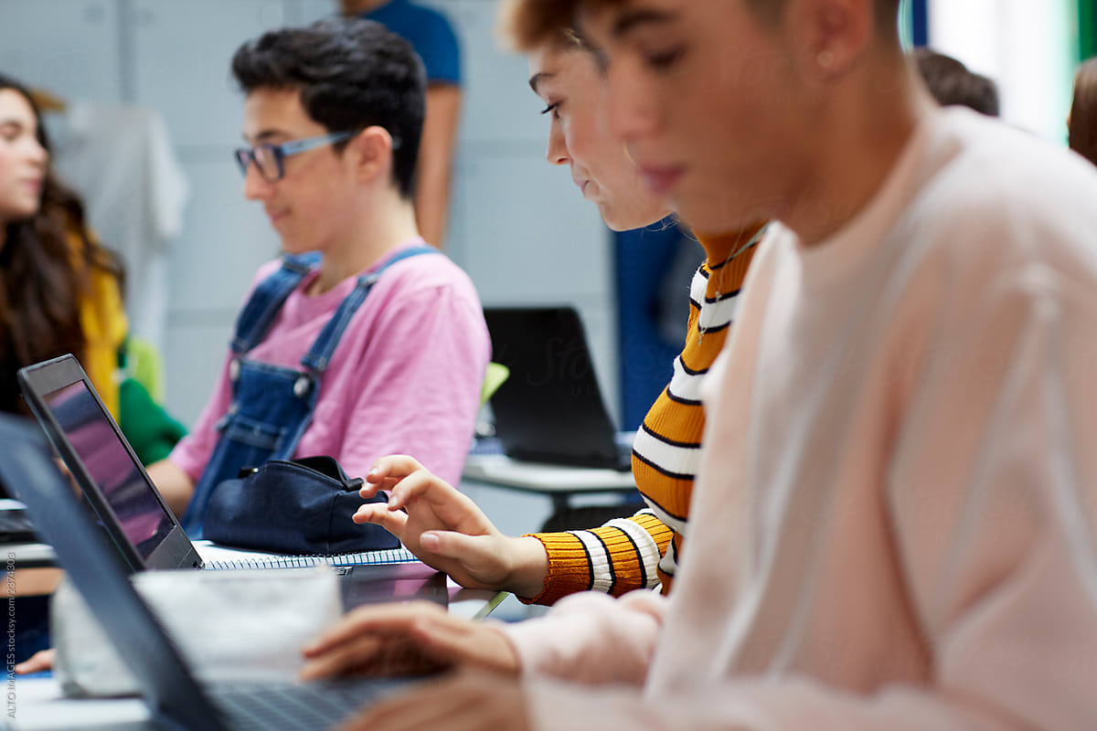 Teenage students using laptops in the classroom