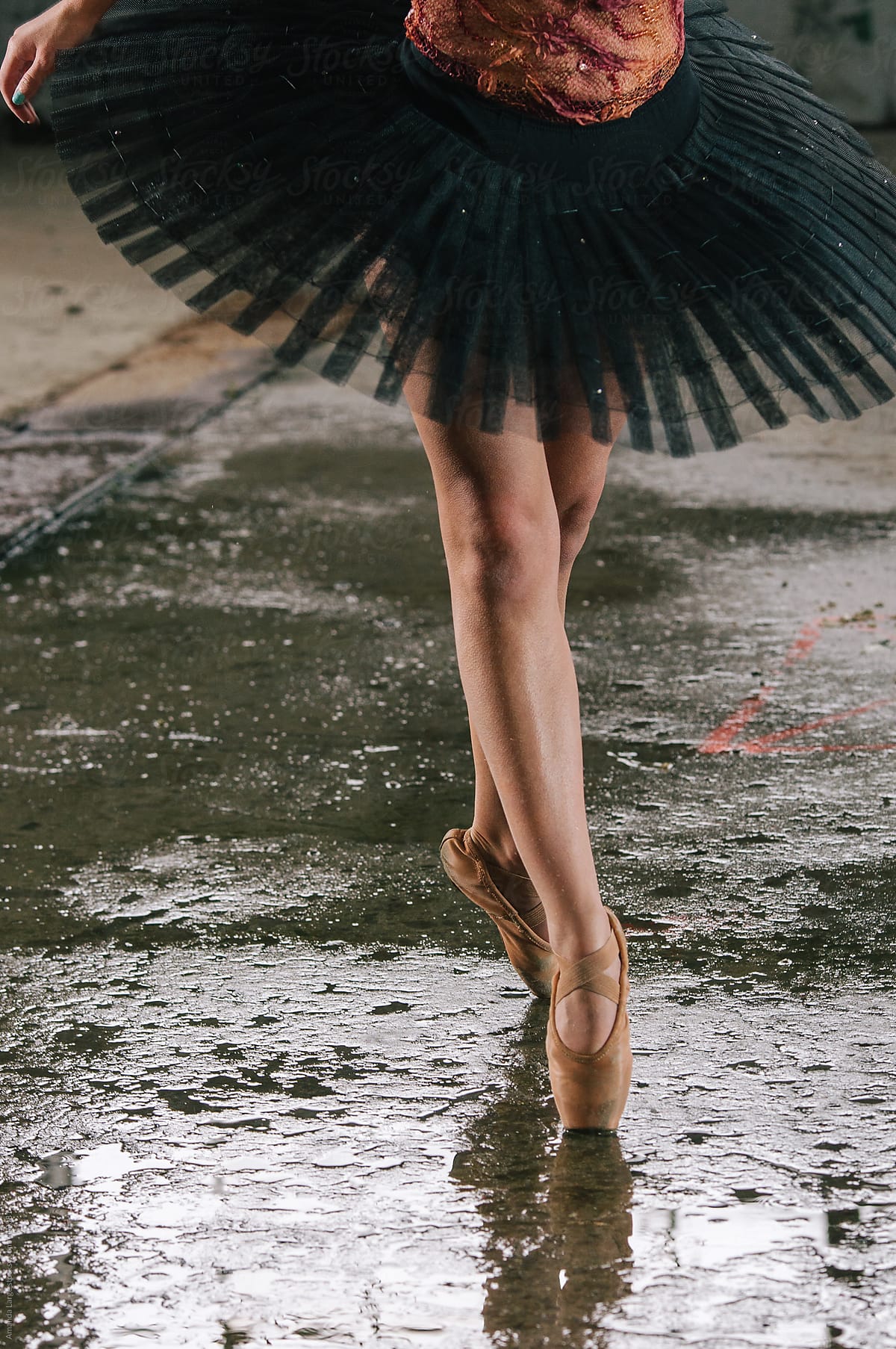 detail of ballet dancer\'s feet in an urban warehouse setting.