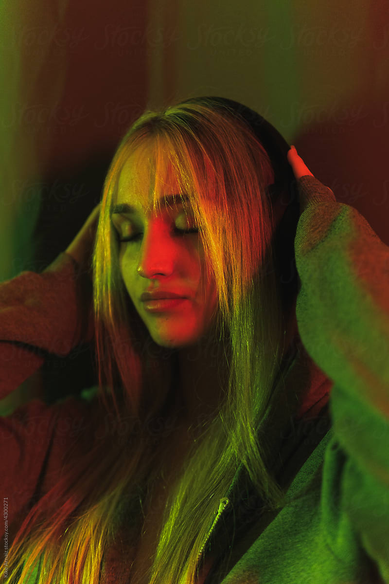 Female listening to music under neon light
