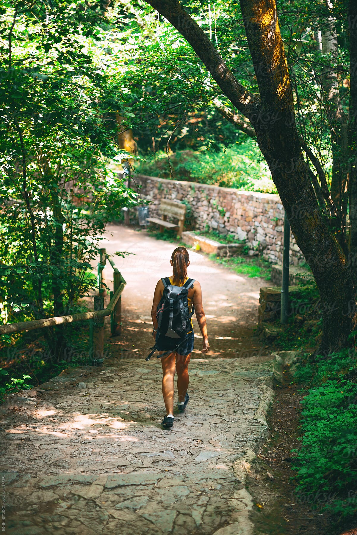 Woman with a backpack walking on forest.