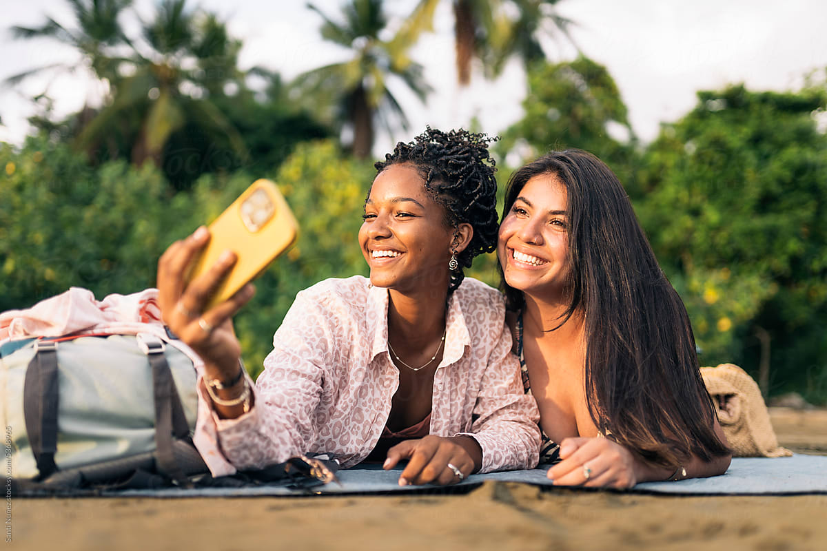 Happy diverse girlfriends taking selfie on holidays