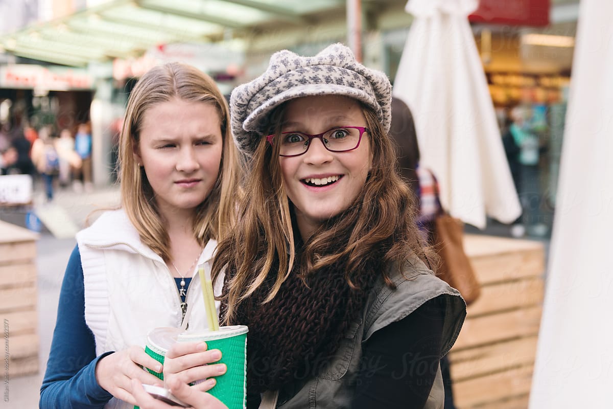 Teen Girl Frowing At Another As She Smiles To Camera By Stocksy