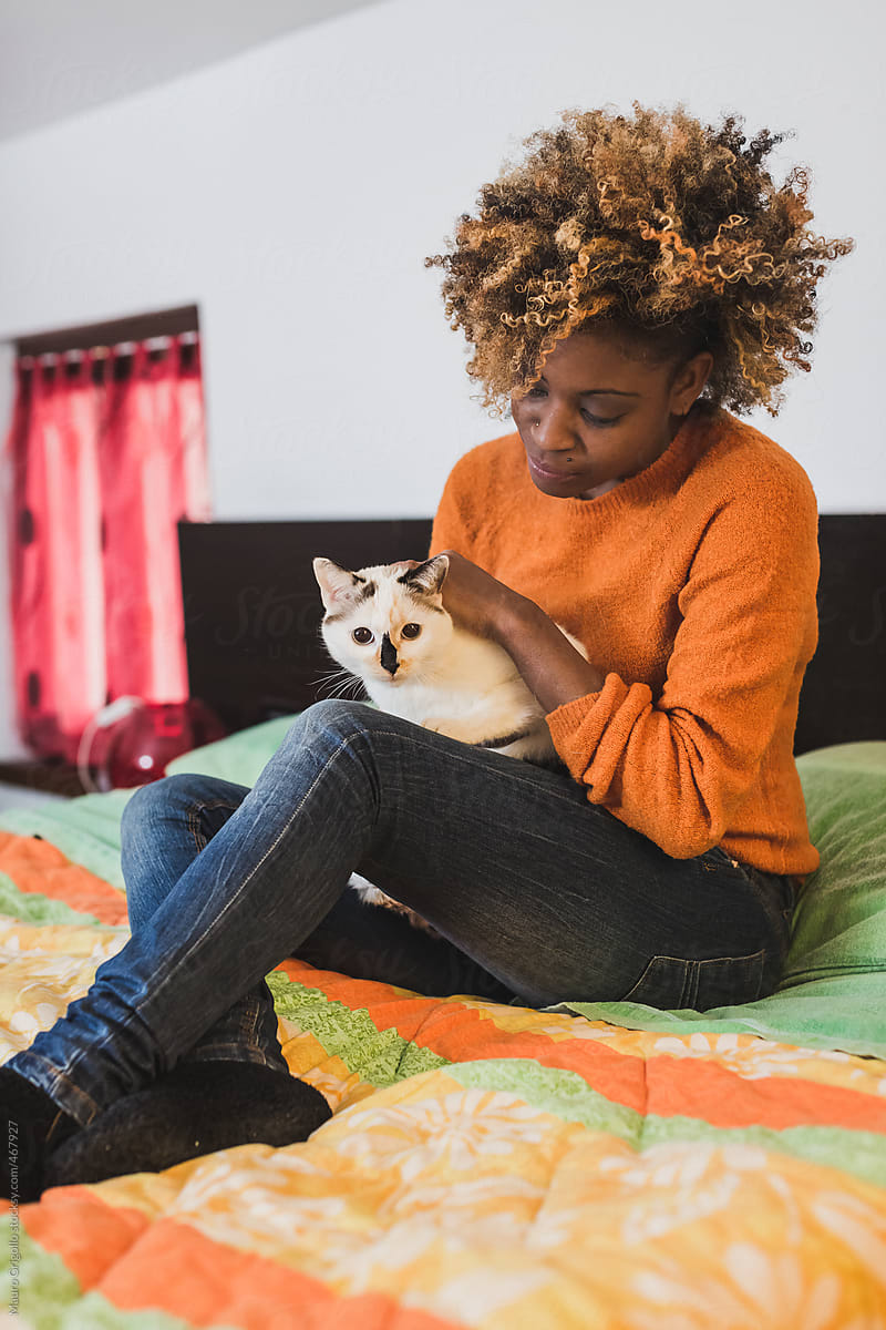 Woman relaxing on the bed with her cat