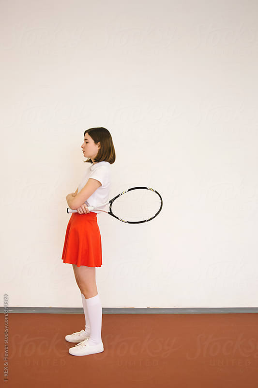 Side view of young woman holding tennis racket