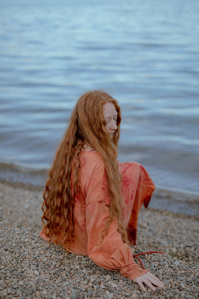 portrait of a red-haired woman near the water
