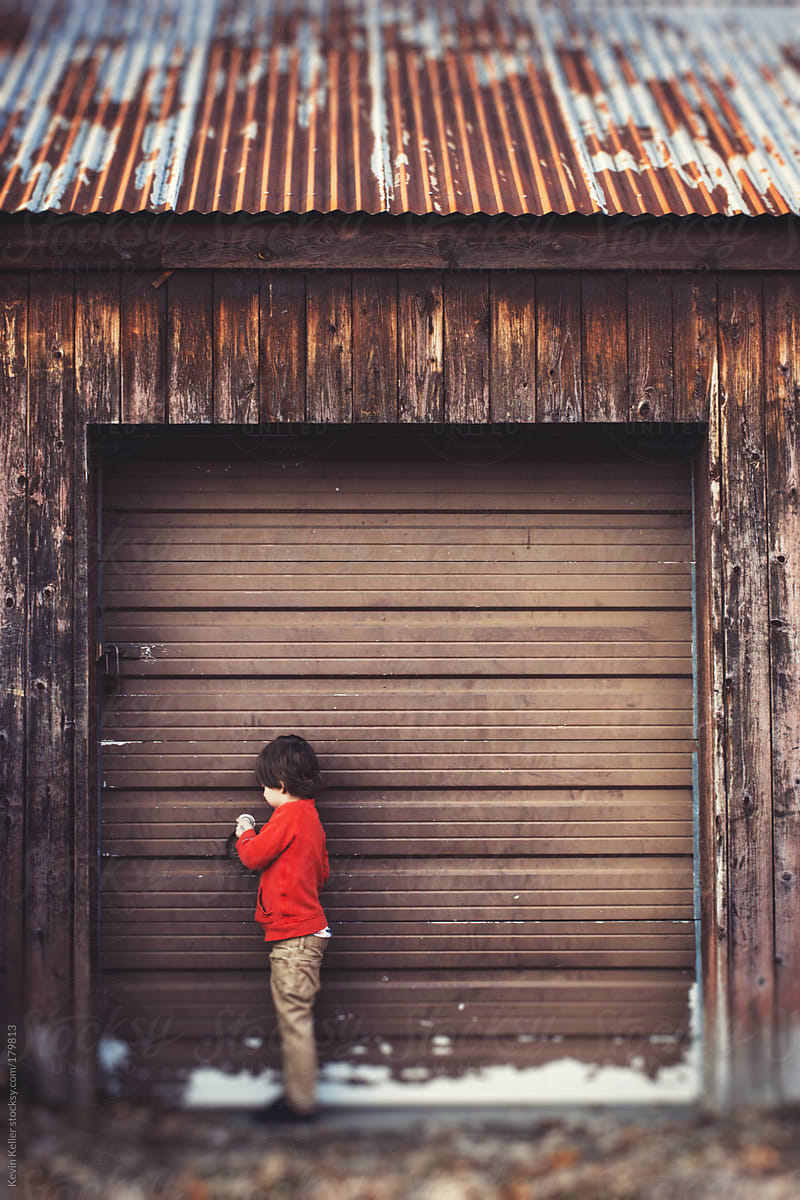 Young Boy Trying to Open an Old Garage Door