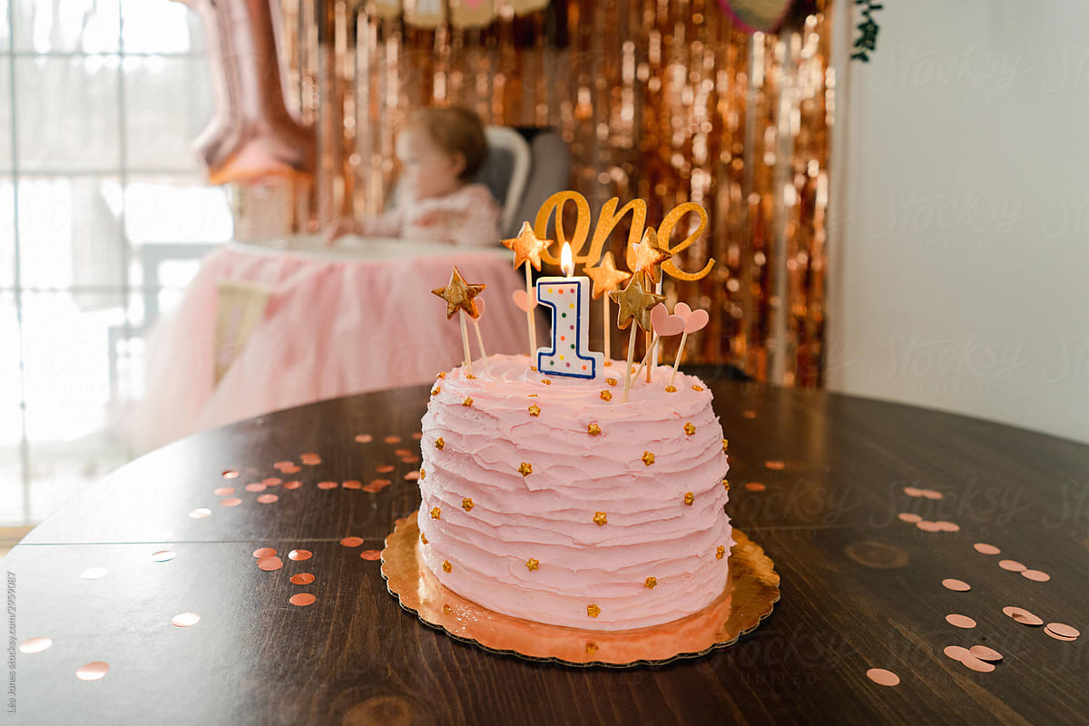 one year old birthday cake, with baby in background