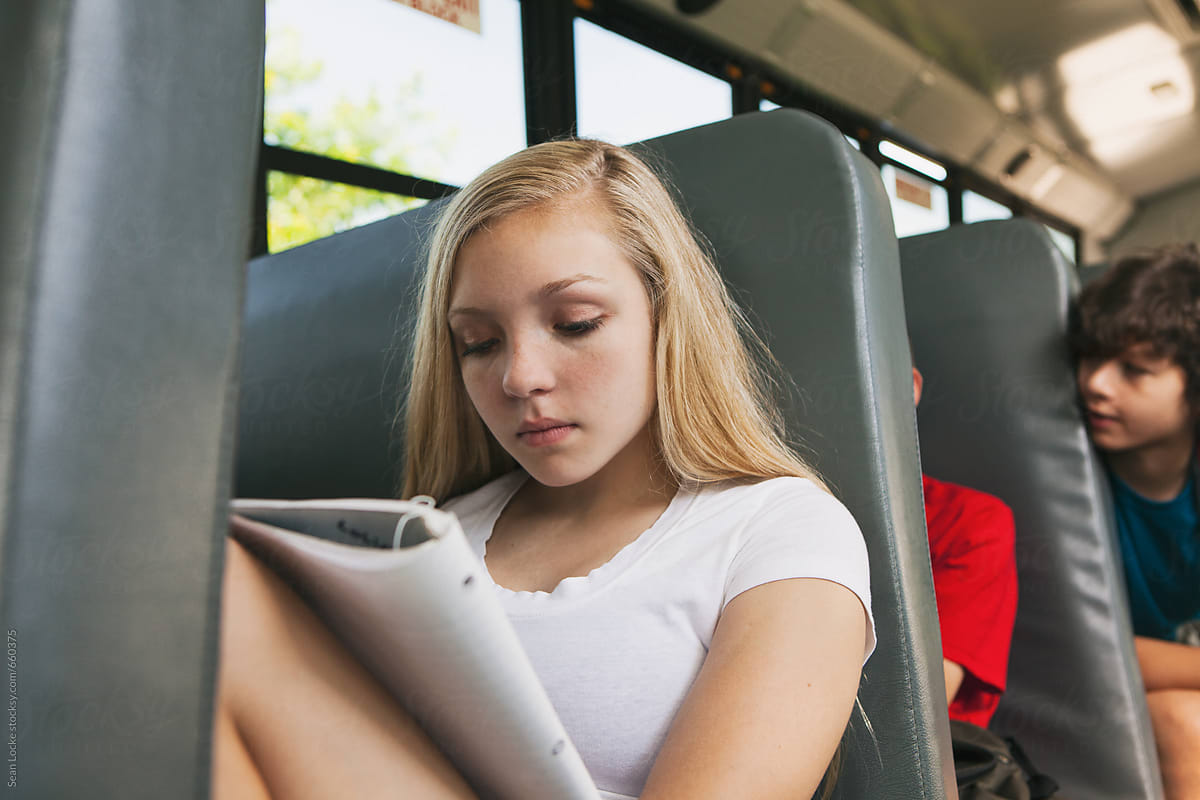 School Bus: Girl Student Studying From Notebook On Bus
