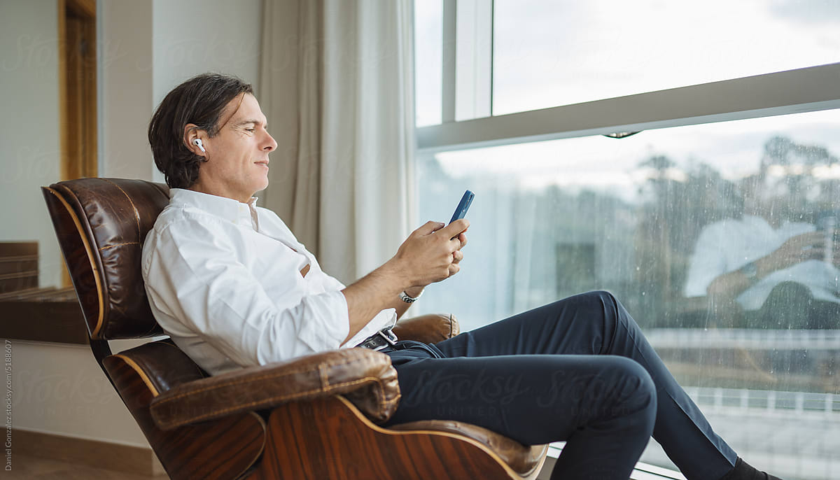 Elegant middle aged man browsing cellphone