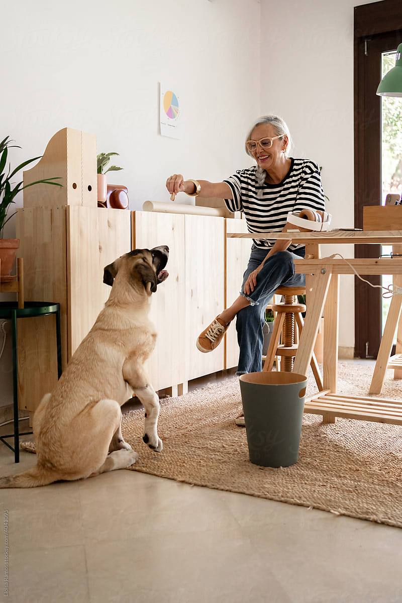 Freelance senior woman at modern studio with her dog