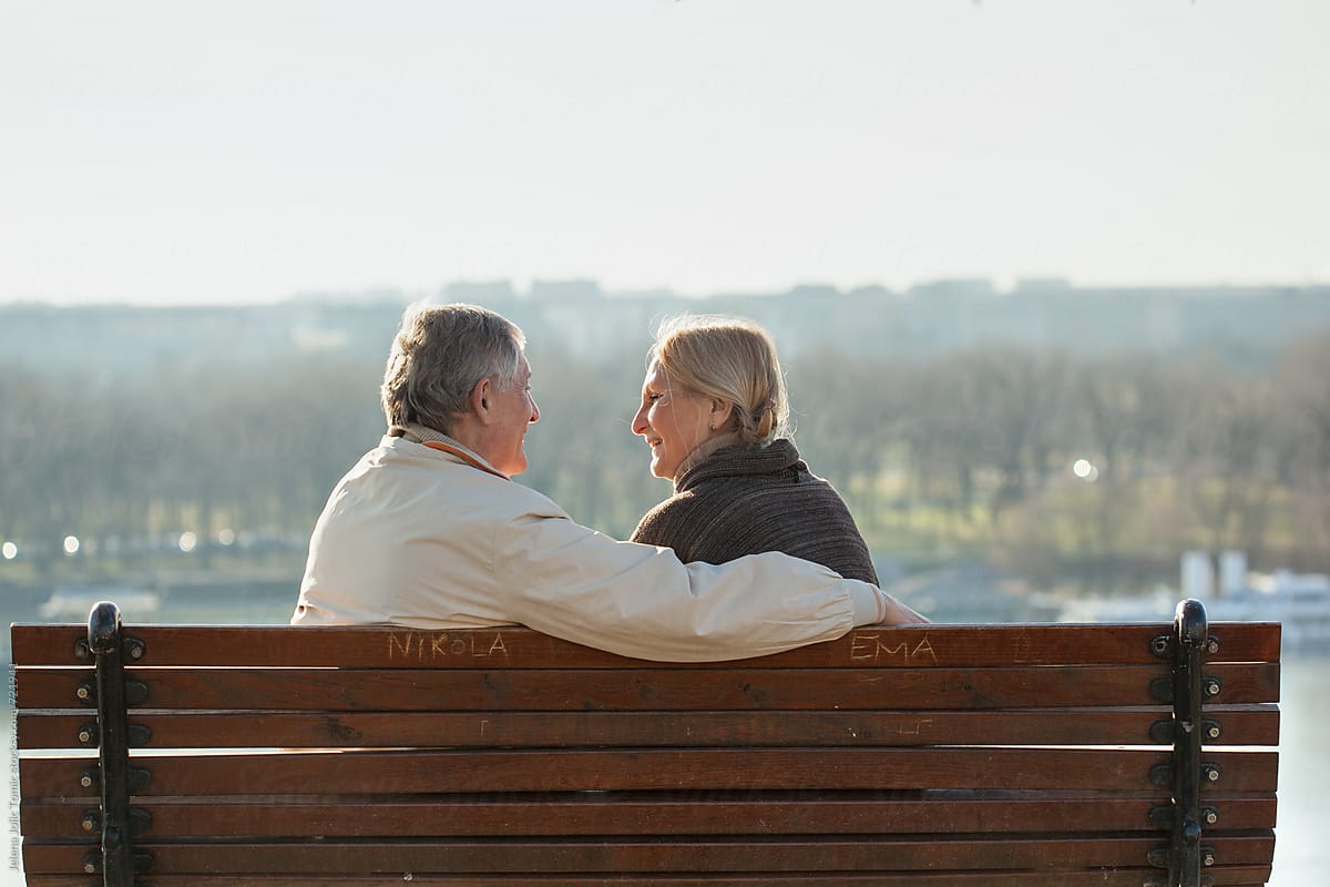 Senior Couple Chats On A Bench By Stocksy Contributor Jelena Jojic
