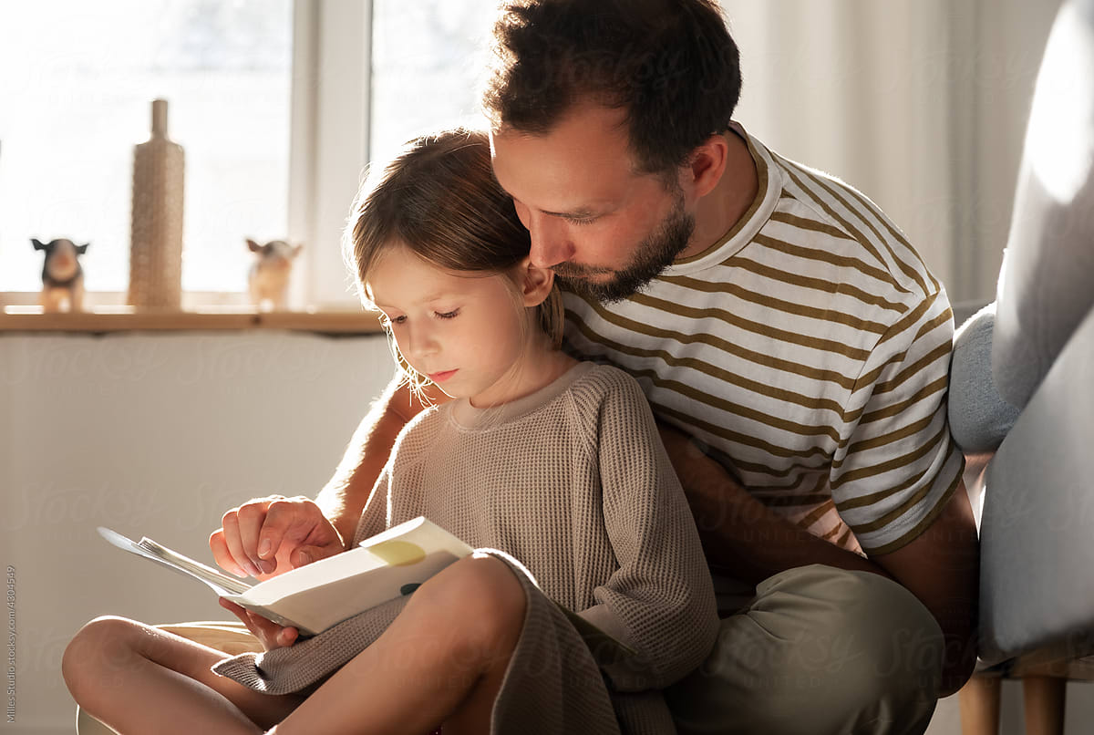 Father and daughter reading story together