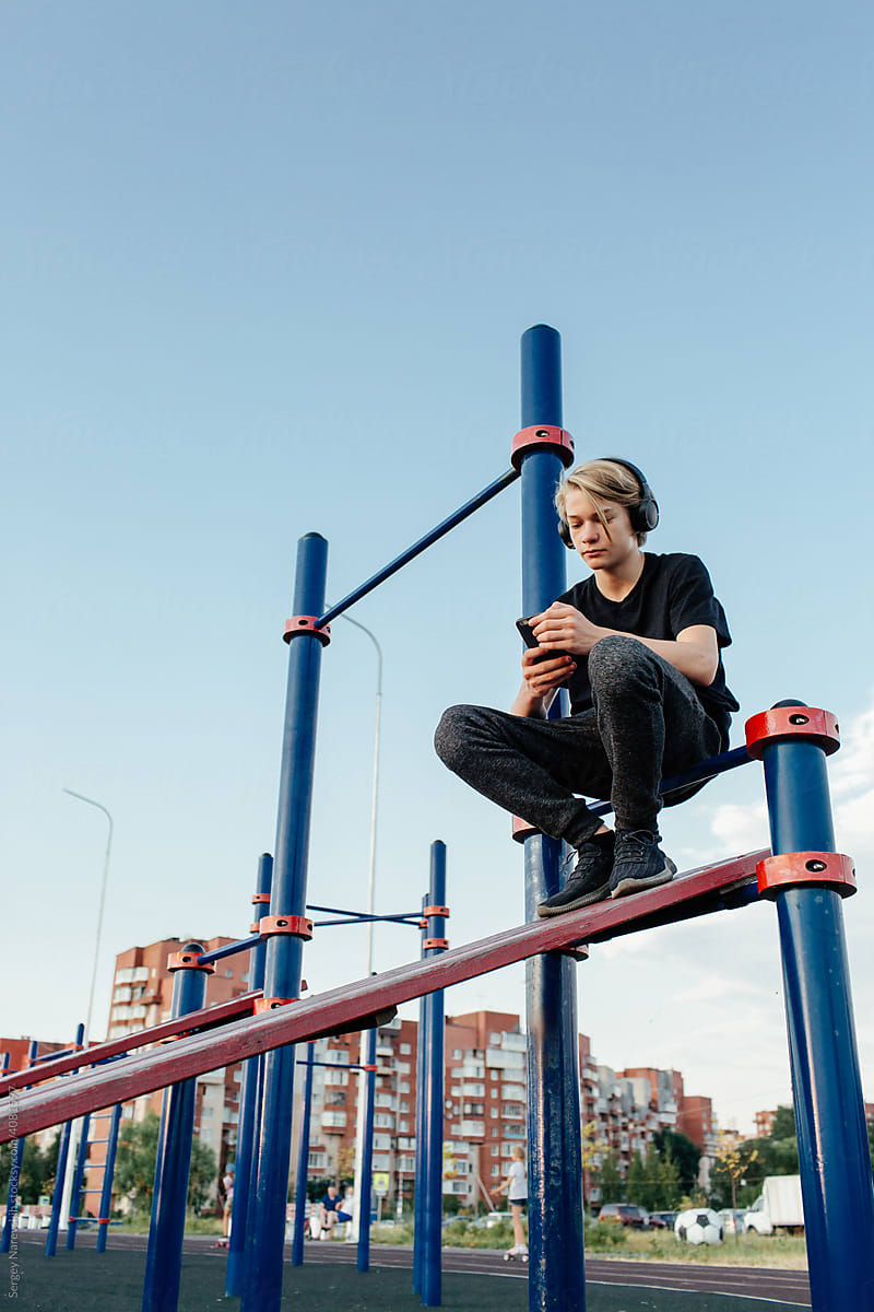Teenager in headphones using smartphone