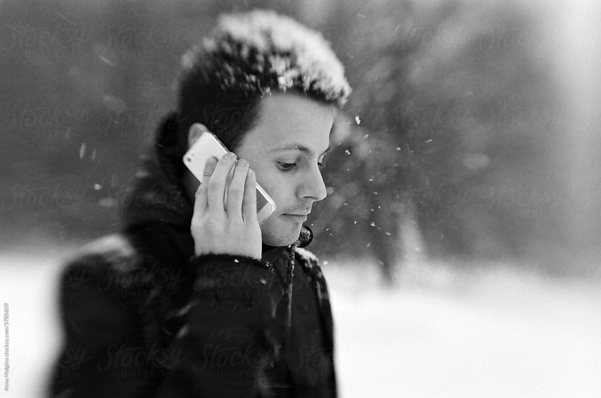 Handsome man with a phone at winter