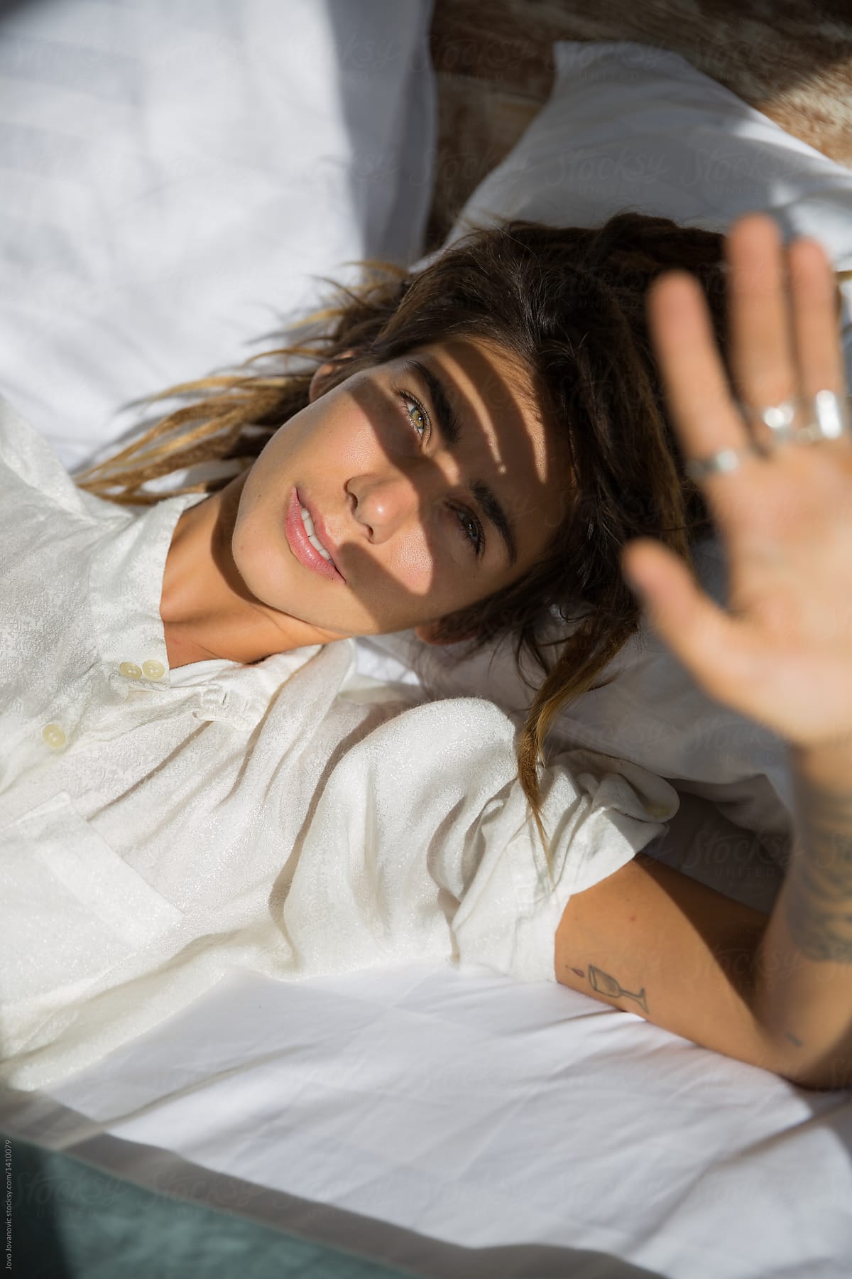 Woman In Bed Hiding Her Face From Sun By Stocksy Contributor Jovo Jovanovic Stocksy 9931