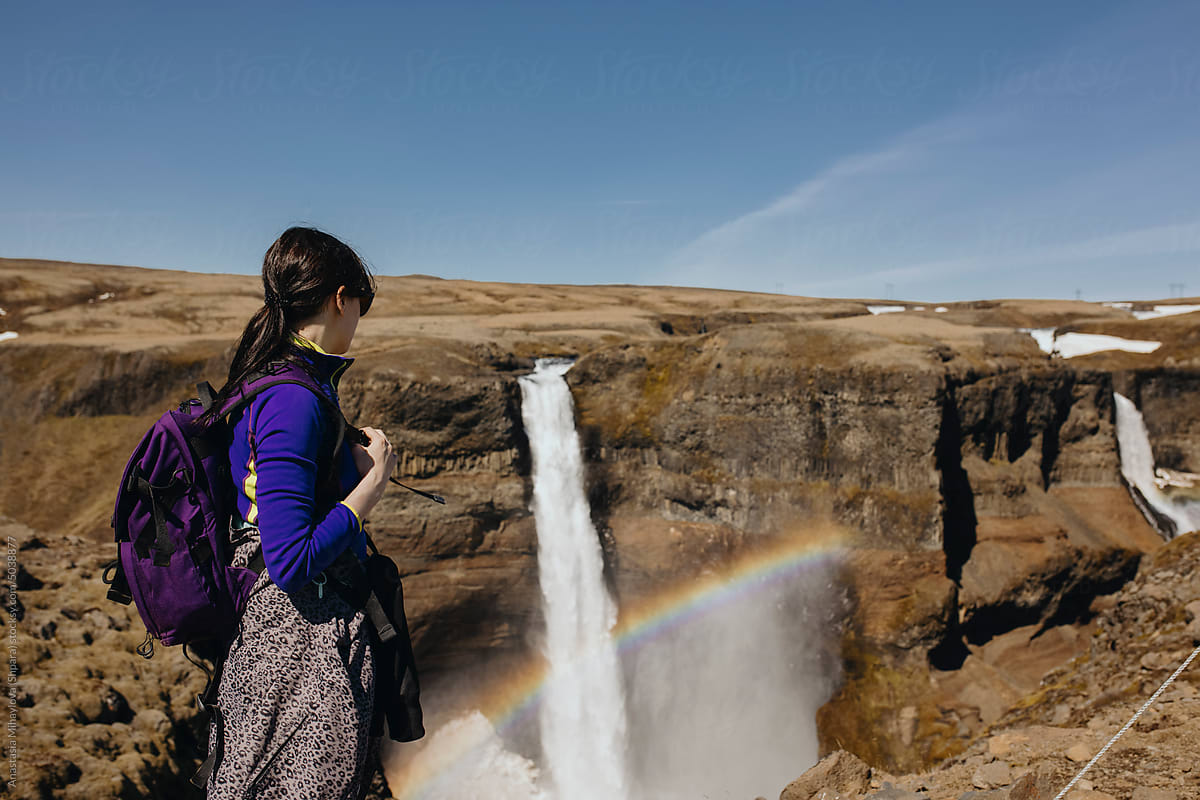 Young Traveller woman With A Backpack near Waterfall In Iceland
