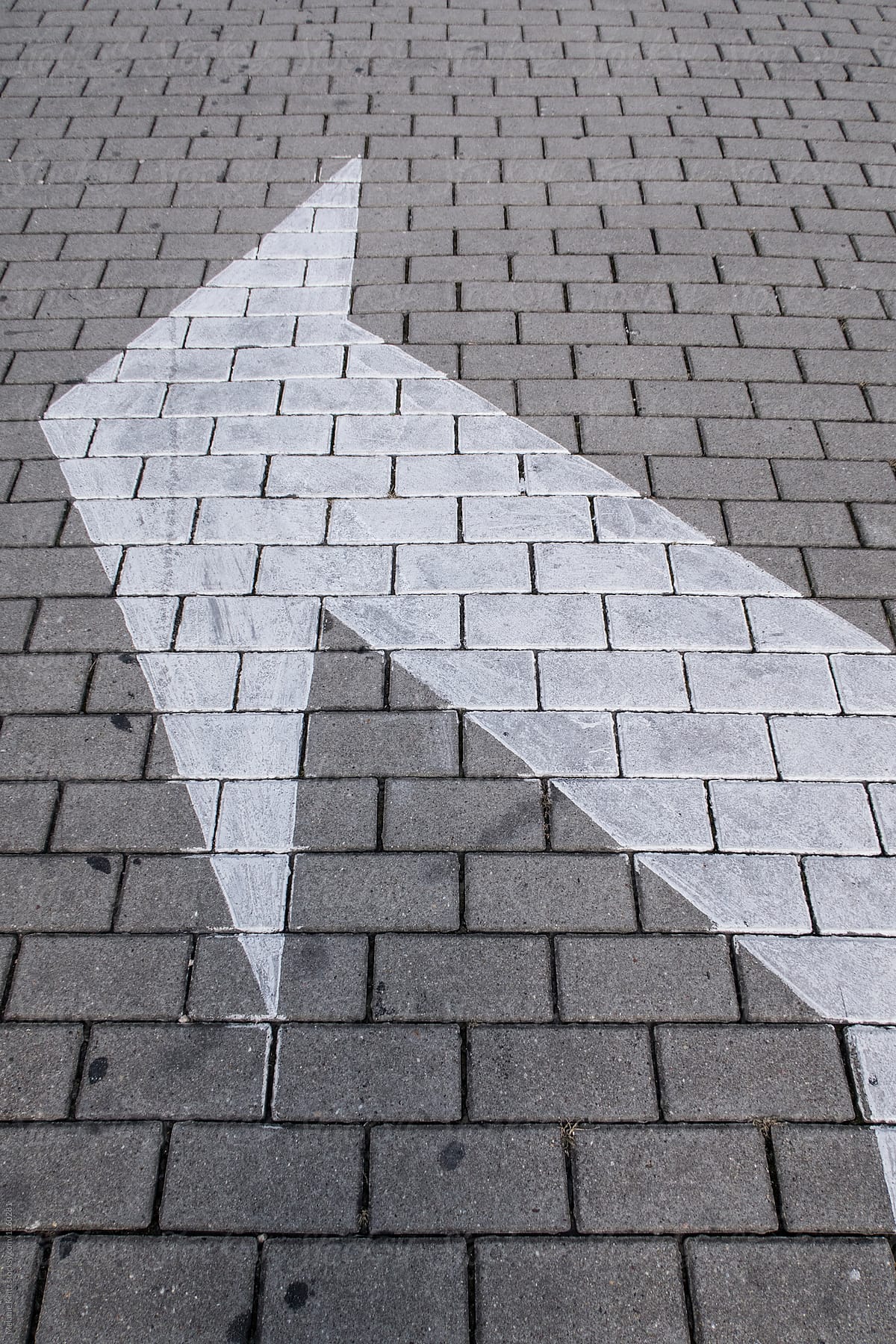 Arrow on pavement pointing to left side