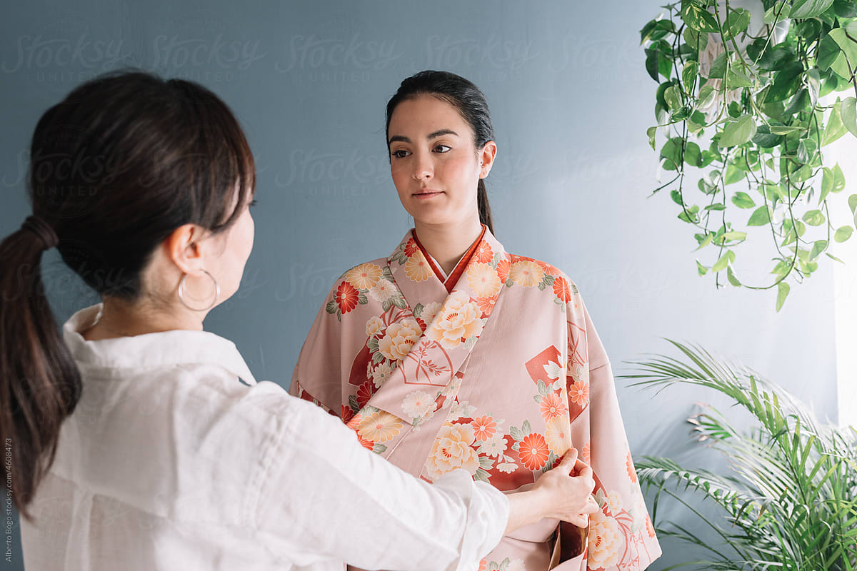 Mother Dressing Daughter With Traditional Kimono