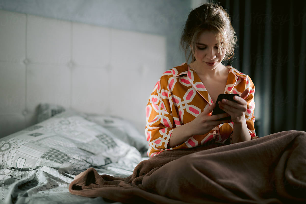 Woman using phone after waking up