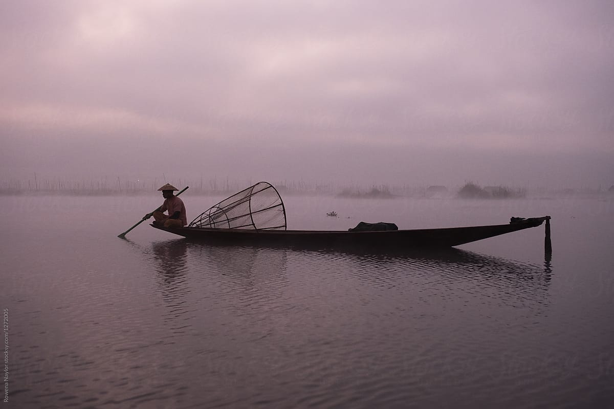 Silouette of traditional Shan fisherman at day break fishing on a misty Inle Lake, Myanmar
