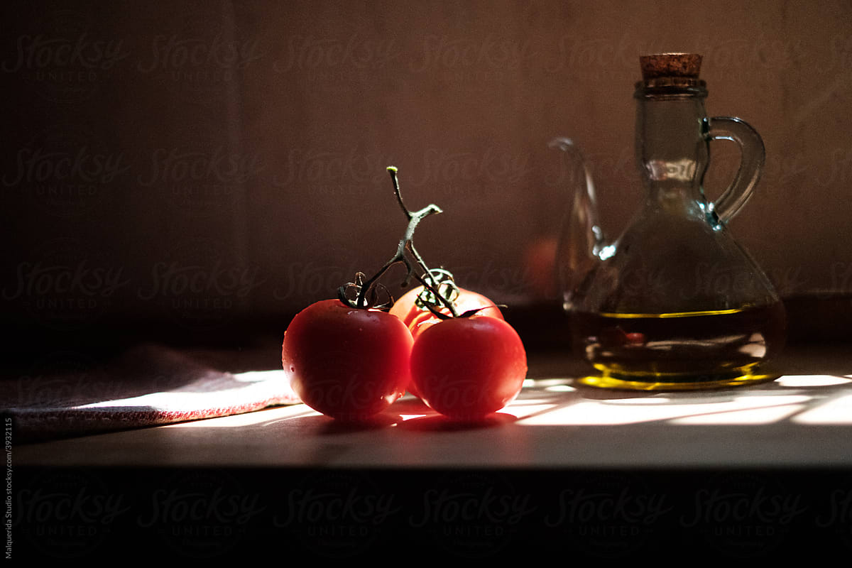 Dark still life with tomatoes and oil can