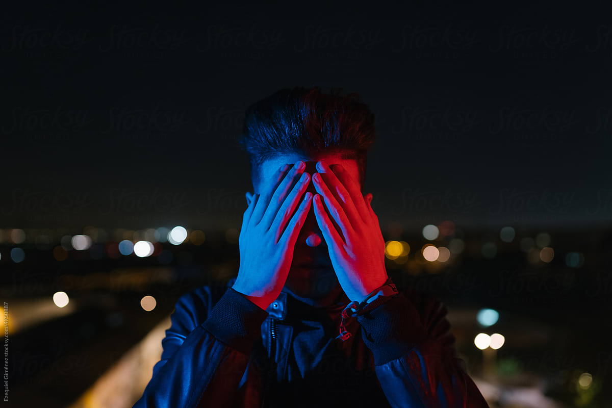 Anonymous guy covering face under night sky