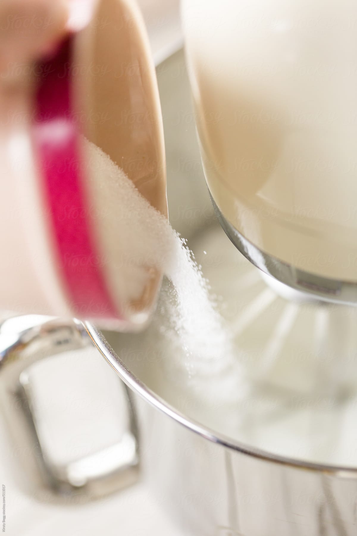 Sugar being poured into whisked egg whites