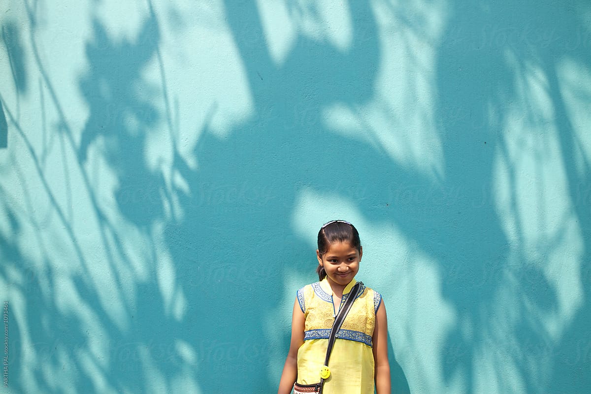 Teenage girl standing against nice shadow on wall